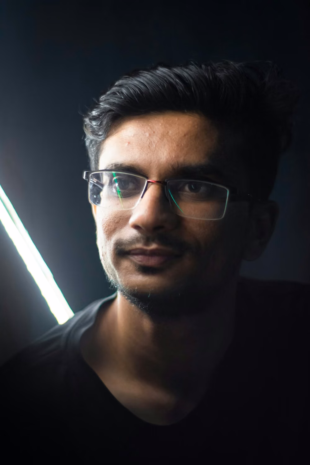 Man in black crew neck shirt wearing black framed eyeglasses
